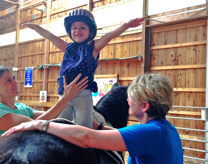 A child practices motor skills and challenges behavioral habits with the help of a horse in hippotherapy